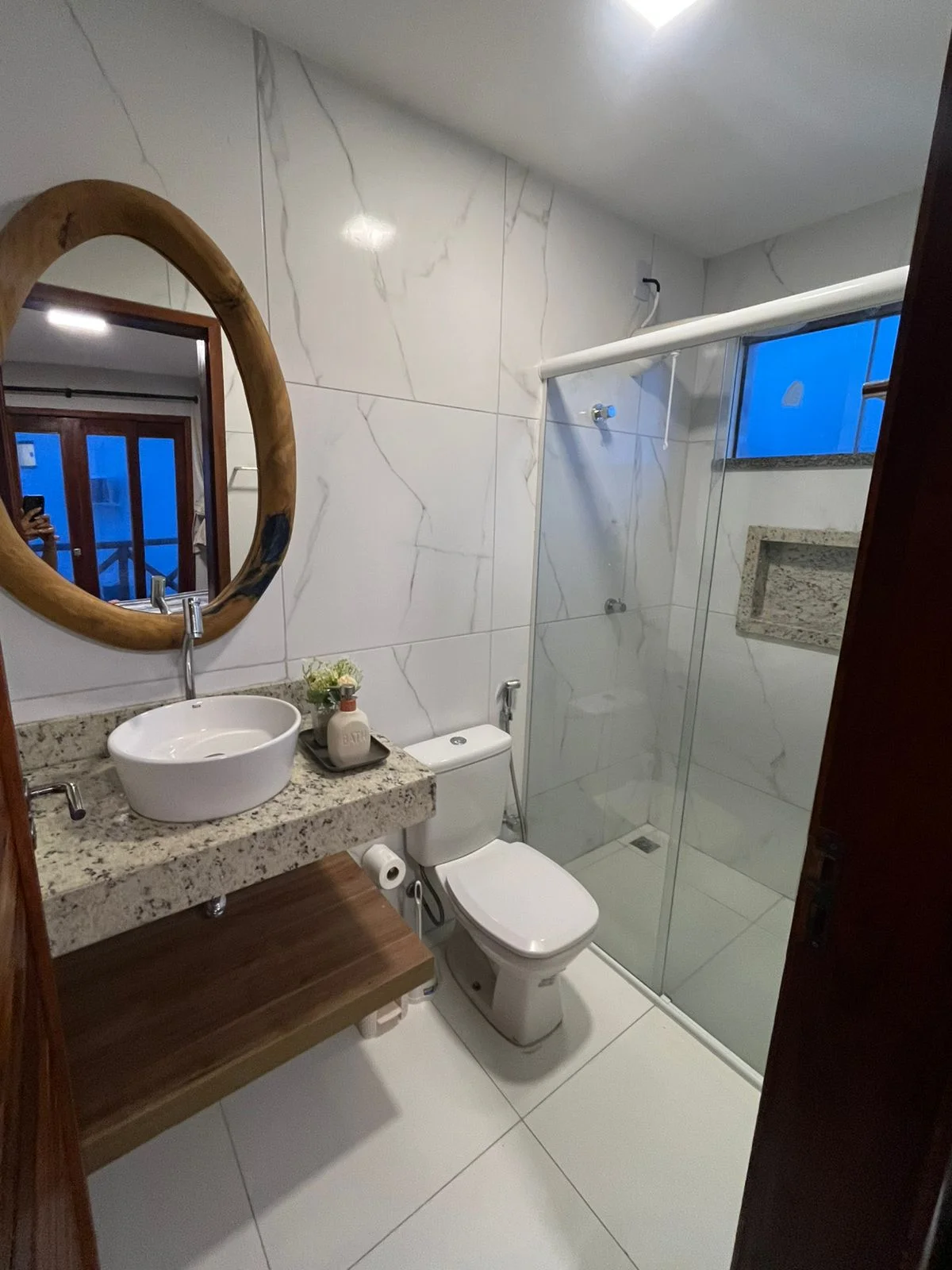 Banheiro com box de vidro.