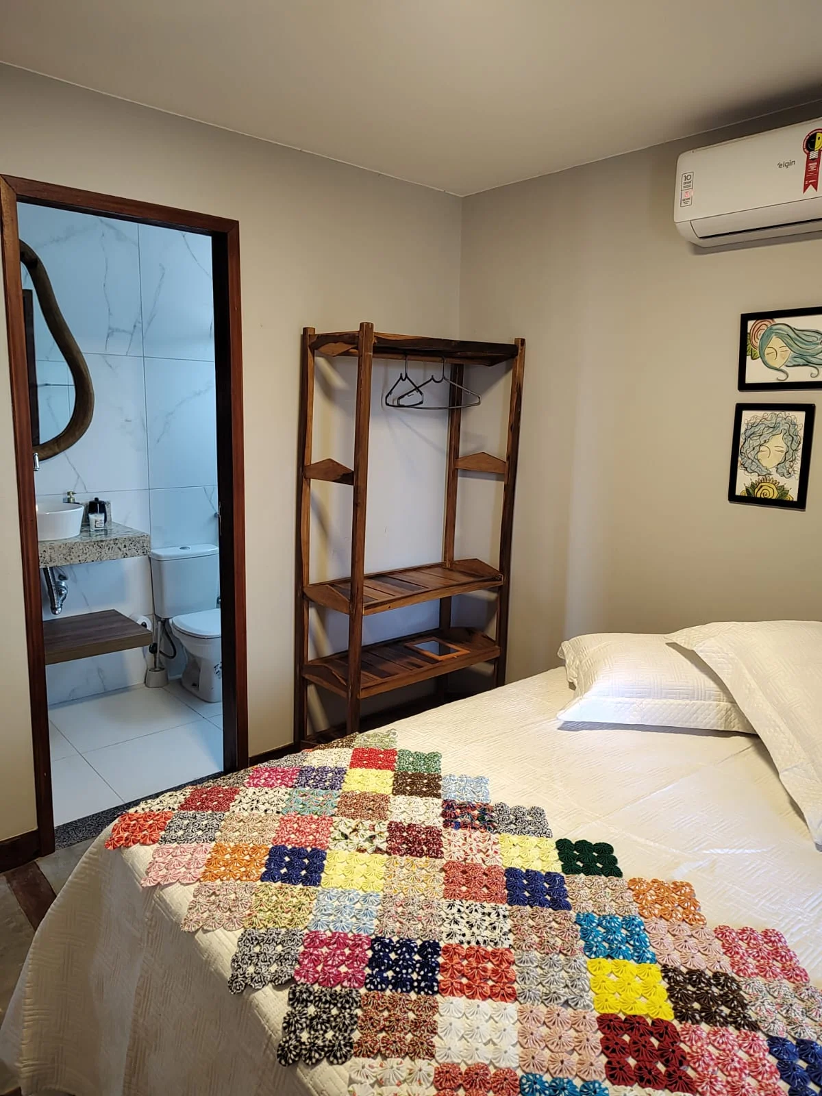 Quarto com cama de casal e banheiro adjacente.