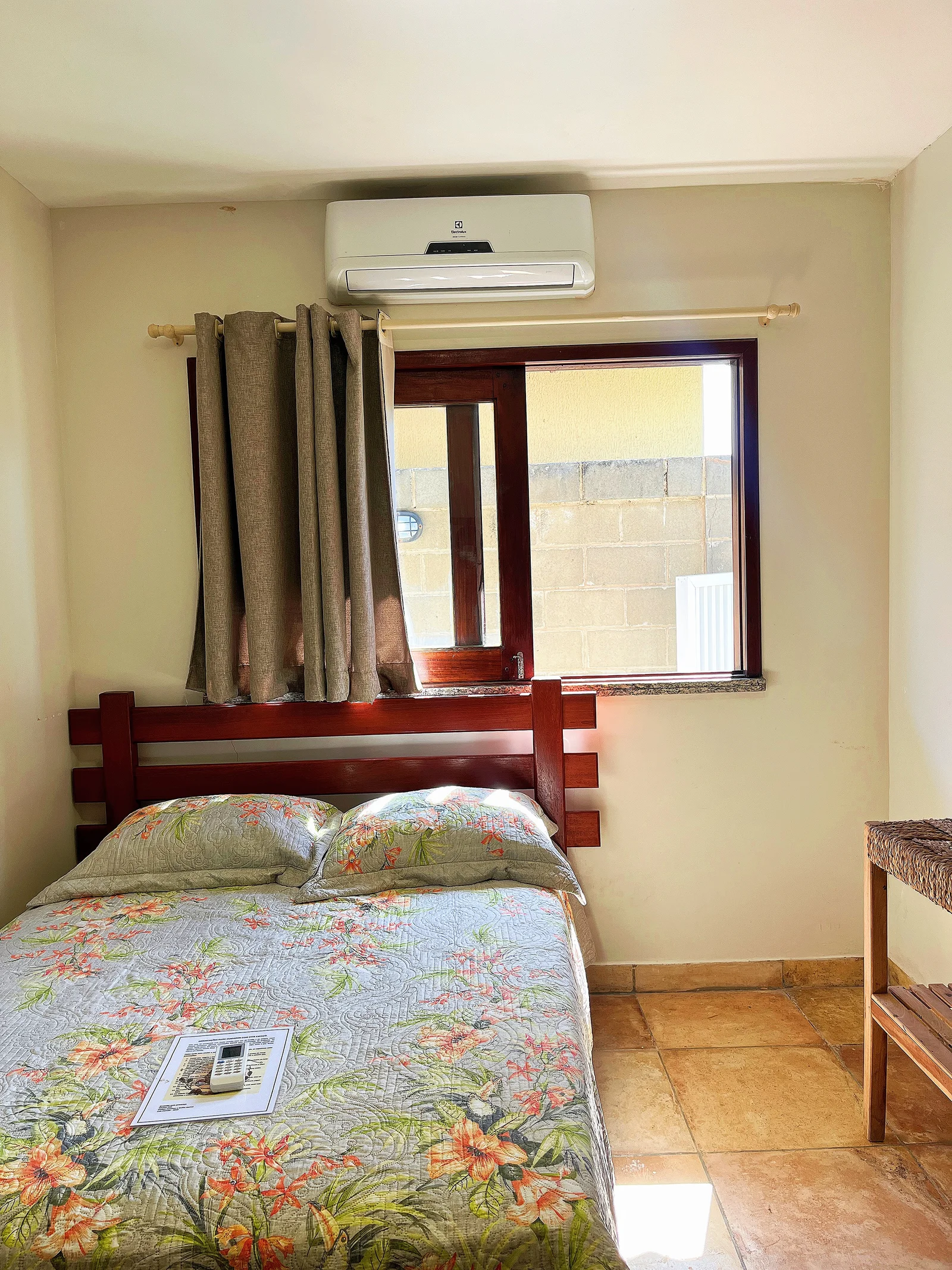 Quarto com cama de casal e ar-condicionado.