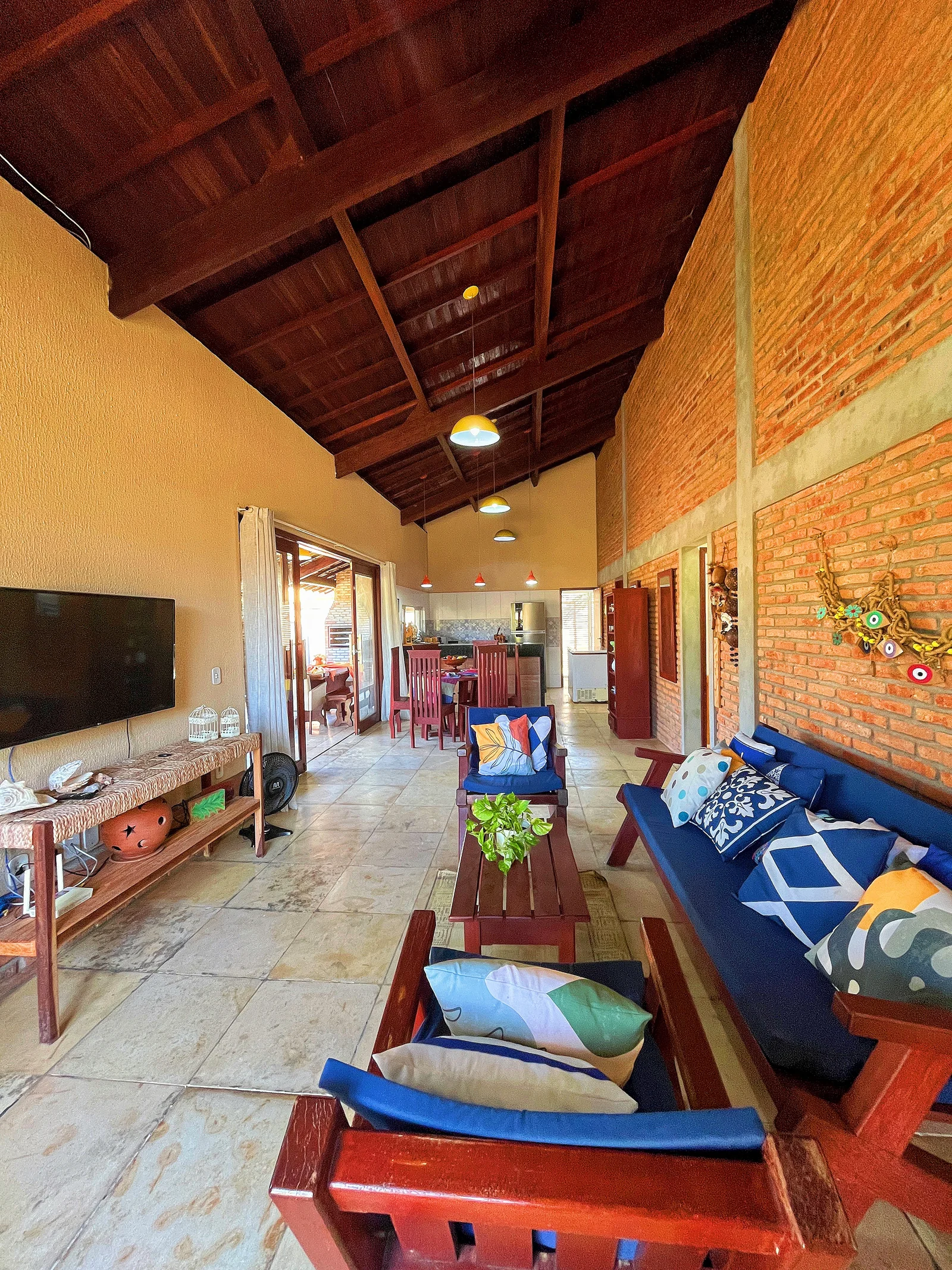 Sala com móveis de madeira e almofadas azuis.